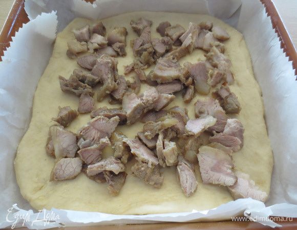 Заранее потушить мясо (растительное масло нагреть, мясо порезать на куски, слегка обжарить, перемешивая. Добавить порезанный красный лук, перемешать, добавить воды. Если хотите добавьте томат пасту или мелко порезанные, очищенные от кожицы свежие помидоры. Посолите, поперчите. Тушите 15 минут)
Готовое мясо порезать на более маленькие кусочки и равномерным слоем выложить на тесто.