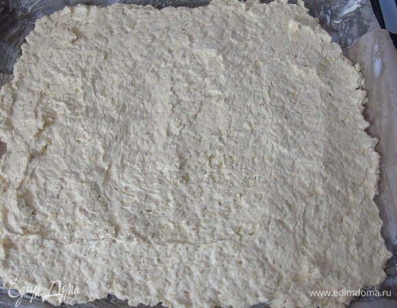 Пергамент смажьте сливочным маслом и выложите тесто, разровняйте ножом.