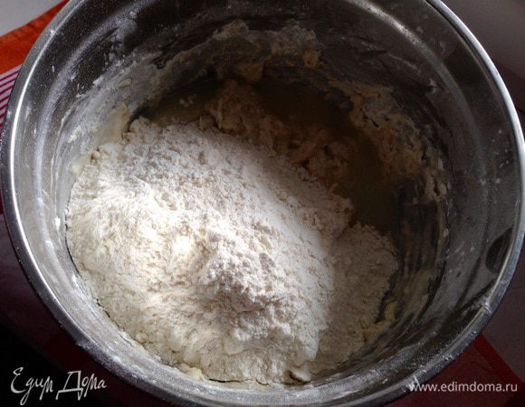Всыпать остальную муку (немного оставим для работы с готовым тестом) и сыворотку. 