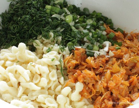 На растительном масле сначала обжарить лук до прозрачности, добавить томатную пасту, перемешать и прогреть 1-2 минуты. Добавить кабачок, обжаривать 5 минут, затем добавить капусту, обжаривать еще минут 10-15, что бы капуста слегка обмякла, остудить. Добавить к макаронам вместе с нарубленной зеленью укропа и лука.