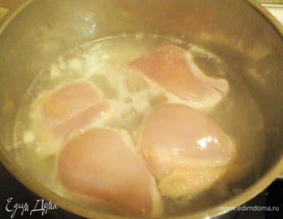 Опускаем кусочки грудки в воду, убавляем огонь.