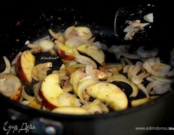 Выложить на эту же сковороду тонко порезанный лук, кулинарный жир, если нужно. Крупное яблоко очищенное и разделенное на 10-12 частей. Обжаривать вместе 5 минут.