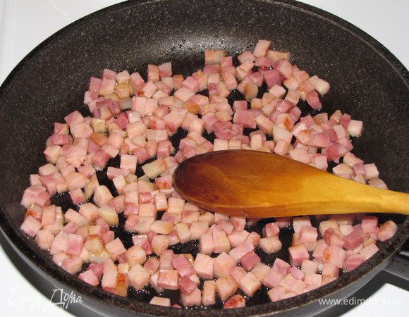 Нарезать ветчину маленькими кубиками и обжарить до золотистого цвета на оливковом масле. Зеленый лук нарезать тонкими колечками.