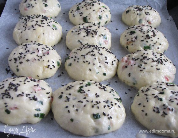 Разогреть духовку до 180 град. Смешать желток с 1 ст. л. воды, смазать булочки и посыпать кунжутом. Поставить в духовку на 15-20 минут.