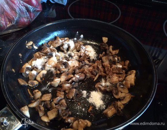 На раскаленную сковороду налейте растительное масло и обжарьте шампиньоны около 10 минут, сделайте огонь тише, посолите, приправьте перцем, мускатным орехом, добавьте муку, перемешайте.