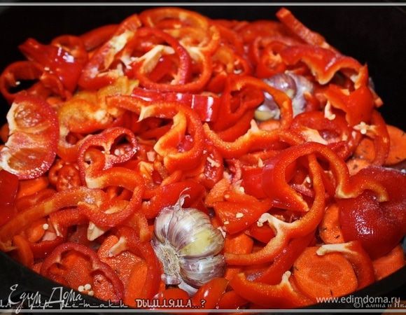 Вот так нарезаем, поверх морковок – помидорок укладываем. Между ними прячем головки чеснока. Целиком.