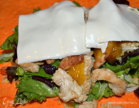 Затем выкладываем обжаренное филе, добавляем соус по вкусу (у меня кисло-сладкий с ананасом и имбирем, он отлично подошел по вкусу). Закрываем пластинками сыра.