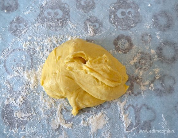 Возьмите лист пекарской бумагой и присыпьте его слоем мукой (как на фото) Визуально поделите тесто пополам и выложите половину теста на пергамент. Поднимите с двух-трех сторон бумагу так, чтобы мука немного припылила тесто, после этого вы сможете перевернуть его и раскатать скалкой (можно еще слегка присыпать при раскатывании. У вас должен получиться круг толщиной примерно 0.5-0.7 мм.