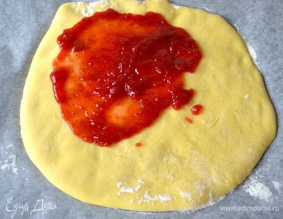 По прошествии указанного времени включите разогреваться духовку на 180 градусов в режиме конвекция!
Снимите верхний лист бумаги с коржа, который находится на противне, и смажьте его клубничным джемом (самым вкусным!)