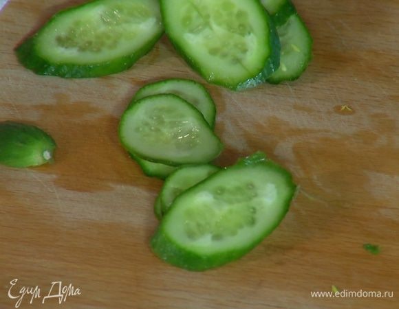 Огурец нарезать тонкими кружками наискосок.