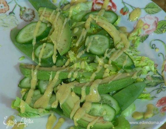 На блюдо выложить салат, сельдерей, огурец, стручки горошка и авокадо, сбрызнуть все заправкой, посолить и поперчить.