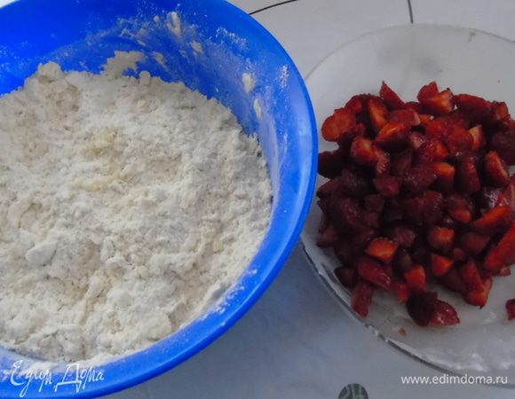 Смешать муку с маслом в крошку, добавить разрыхлитель и сахар. Клубнику почистить и нарезать.
