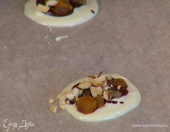 Разложить в шоколадные круги орехи, курагу и изюм.