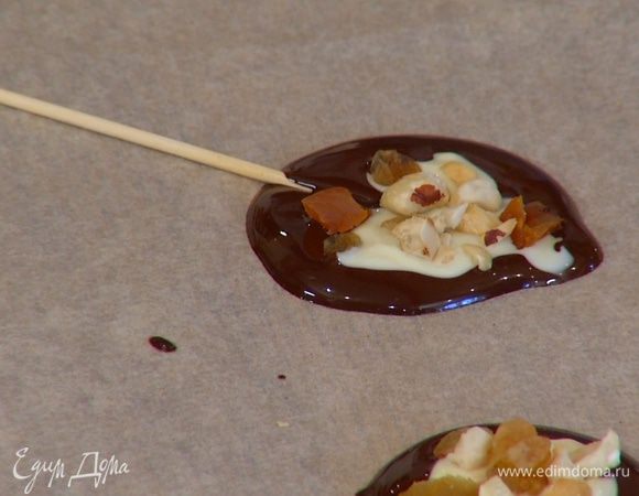 Поместить на кружки небольшие деревянные шпажки, чтобы получилась конфета на палочке. Дать шоколаду полностью остыть.