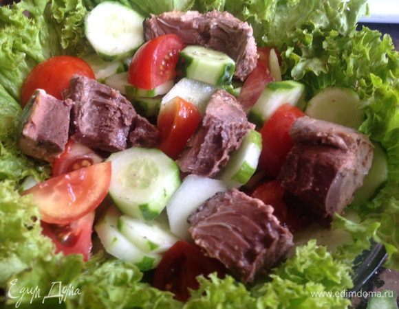 Слейте жидкость с тунца и выложите кусочки на салат. Сверху выложите маслины.