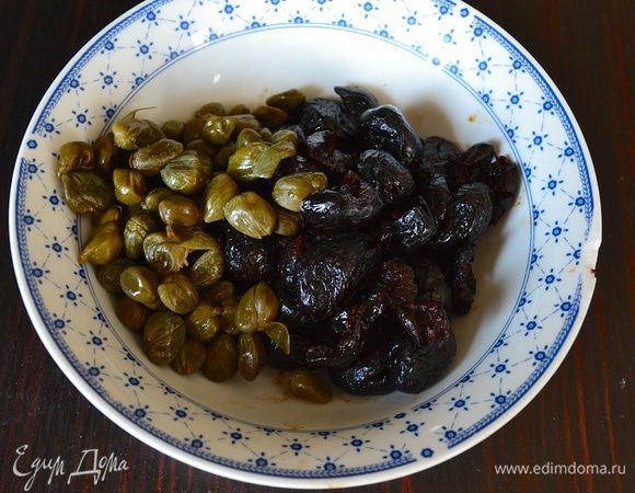 Кастрюлю с водой поставить на огонь и дать закипеть. Посолить воду и положить вариться пасту согласно времени, указанному на упаковке. Тем временем займемся приготовлением соуса к пасте. Из маслин удалить косточки, каперсы промыть от соли и дать стечь лишней жидкости.