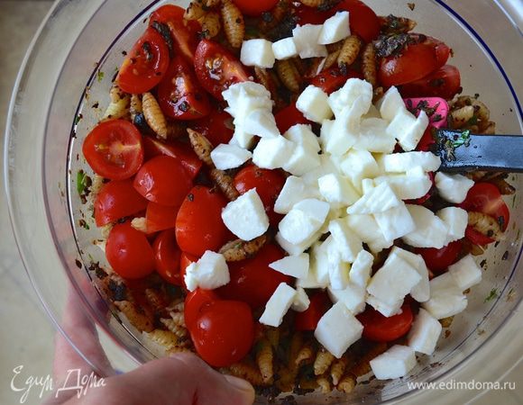 Помидорки черри вымыть и нарезать пополам или четвертинками (всё зависит от размера помидорок) и добавить к пасте вместе с нарезанной маленькими кубиками моцареллой.