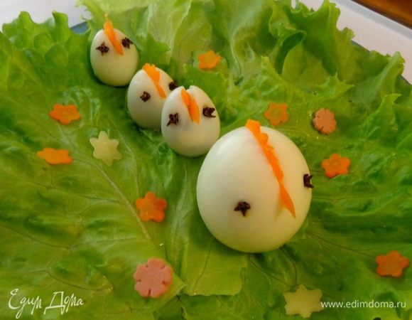 Отварить вкрутую куриные и перепелиные яйца. Из морковки сделать клювики и гребешки. Расположить на листьях салата.