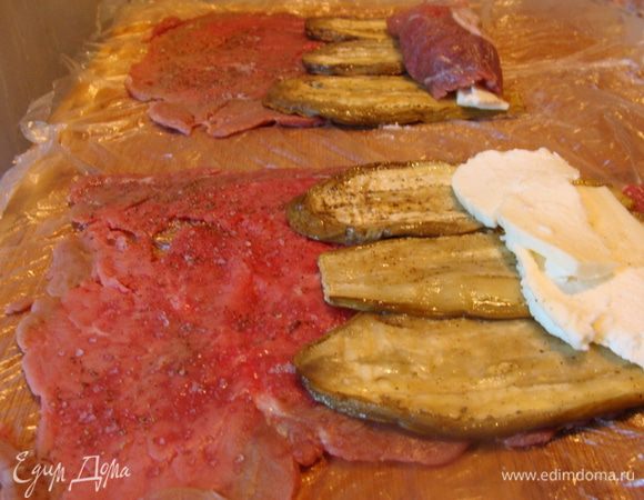 Мясо отбить так, чтобы получились очень тоненькие пласты. Посолить и поперчить.
Выложить сверху баклажаны, у меня по 3-4 кусочка получилось на 1 пласт мяса.
Сверху по кусочку или по два сыра.