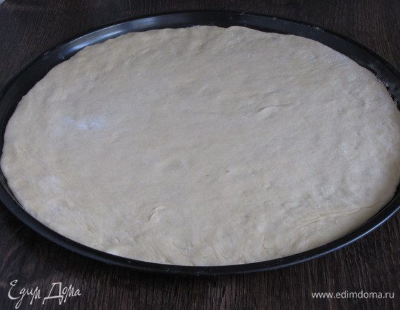 Когда тесто подойдет, обмять его еще раз. Выложить на присыпанную мукой поверхность и раскатать в круг. У меня круг 30 см. Тесто с помощью скалки перенести в форму или на противень.