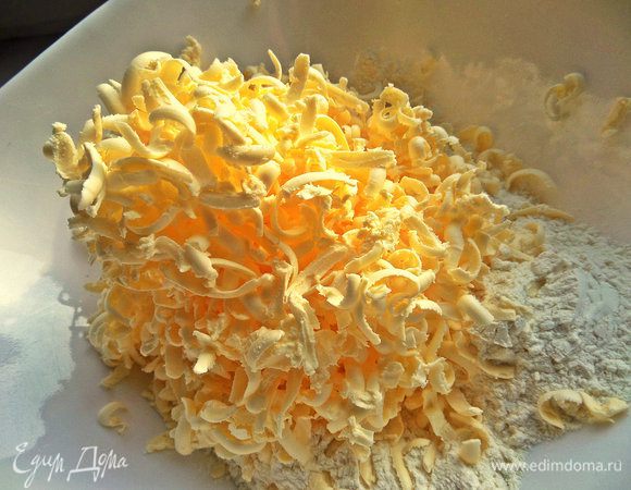 Готовим тесто. Замороженное масло натереть на тёрке в просеянную муку с содой. Муку вначале не всю высыпаем.