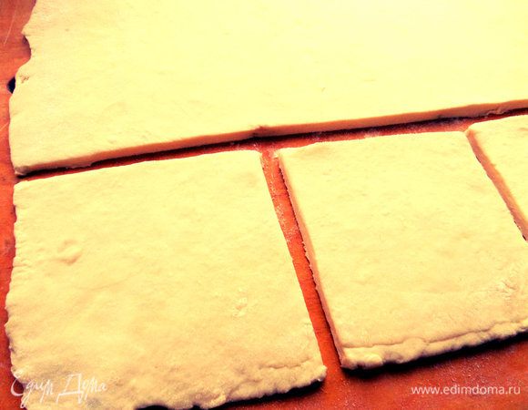 В это время достаём тесто, отрезаем часть (тесто останется), раскатываем в пласт и делим на квадраты.