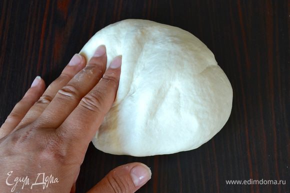 Выложите тесто на слегка присыпанную мукой рабочую поверхность и вымесите его минут 7 (руки можно слегка смазать оливковым маслом, чтобы не подсыпать дополнительно муки).