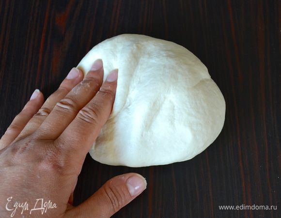 Выложите тесто на слегка присыпанную мукой рабочую поверхность и вымесите его минут 7 (руки можно слегка смазать оливковым маслом, чтобы не подсыпать дополнительно муки).