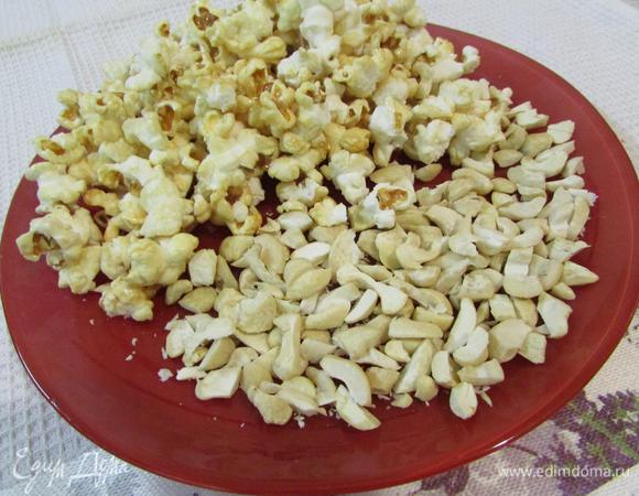 Подготовить попкорн и орехи. Кешью слегка прокалить на сковороде. Крупные кусочки разрезать пополам.