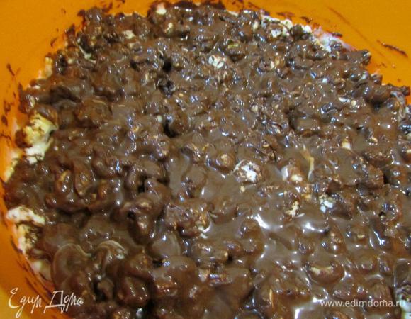 Сверху орехов вылить молочный шоколад. По желании при помощи зубочистки сделать мраморные разводы. Поставить форму в холодильник и дать шоколаду застыть.