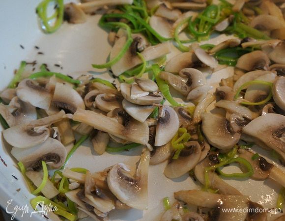 Лук-порей и шампиньоны нарежьте любым удобным для вас способом. В сковороде с толстым дном разогрейте растительное масло, добавьте кумин и слегка обжарьте до появления приятного аромата. Добавьте шампиньоны и лук-порей, обжарьте в течение 1 минуты. 