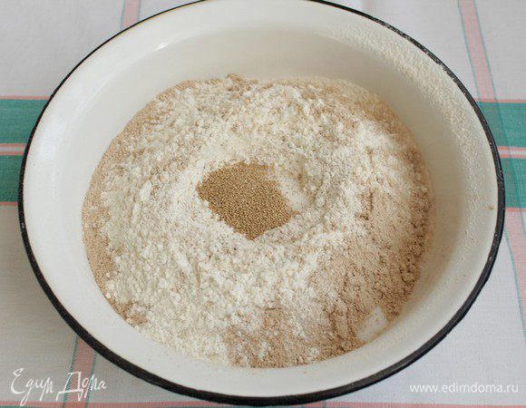 Просеиваем пшеничную, гречневую муку, делаем небольшое углубление, насыпаем сухие дрожжи. 