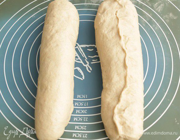 Делим тесто пополам, придаем кускам теста форму батонов и укладываем их на противень.

