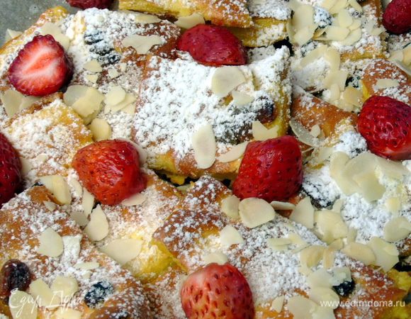 Разложить по тарелкам, посыпать миндальными лепестками и сахарной пудрой. Добавить клубнику.