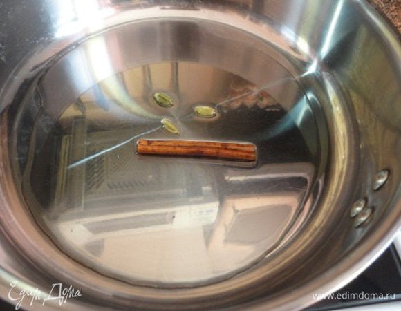 На среднем огне разогрейте в глубокой сковороде или сотейнике масло,  бросьте туда стручки кардамона и палочку корицы. Через минуту удалите их из сковороды.