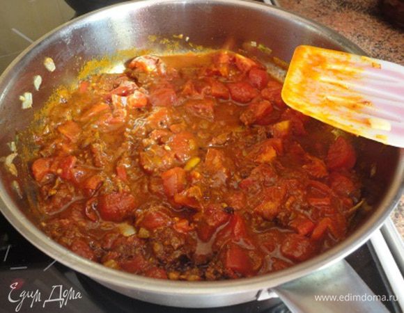 А в этом ароматном масле обжарьте лук до золотистого цвета, у меня на это ушло минут 5. Добавьте вторую часть имбиря, чеснока, перчик чили и, помешивая, готовьте 1 минуту, затем всыпьте подготовленную смесь пряностей и хорошо перемешайте. Теперь выложите помидоры вместе с соком, томатную пасту.