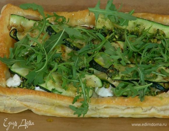 Готовый пирог сбрызнуть оставшимся оливковым маслом и украсить руколой.