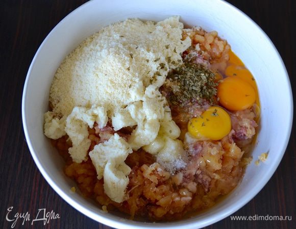 Приготовьте фарш из куриной грудки, добавьте свиную колбаску, 2 яйца, тертый сыр пармезан, отжатый от молока хлеб, измельченную зелень петрушки и щепотку соли. 
