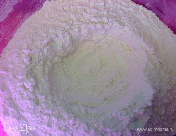 Высыпаем муку в емкость, в которой будем месить тесто, делаем углубление посередине.