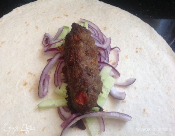 Выложите на тортильи овощи и сверху котлету, заверните.