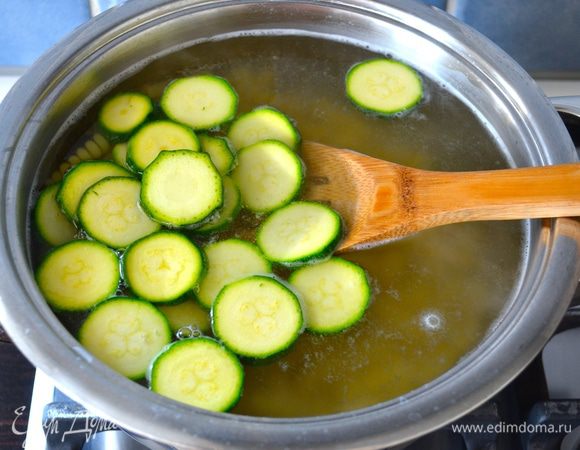Предварительно в большой кастрюле поставьте закипать воду. Как только вода закипит, посолите её и выложите вариться пасту фузилли согласно времени, указанному на упаковке. За 5-6 минут до окончания варки макарон добавьте к ним нарезанные цукини. 