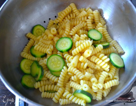 Скиньте пасту с цукини на дуршлаг.