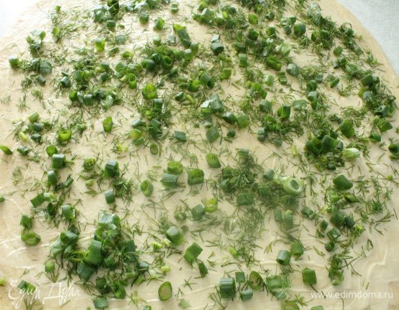 Стол слегка посыпать мукой и раскатать тесто в пласт толщиной примерно 5 мм, тесто очень податливое и хорошо раскатывается. Равномерно распределить по всей поверхности теста размягченный маргарин и затем зелень.