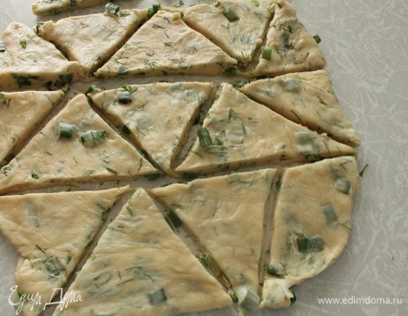 Достать тесто из холодильника и раскатать в пласт толщиной 1 см. Острым ножом нарезать тесто на треугольники или квадраты. Можно и вырезать любые фигурки с помощью формочек для печенья. Я часть сделала с помощью стакана, но мне не очень понравились изделия после выпечки. Края у стакана не острые и слоечки получаются не совсем слоистые.