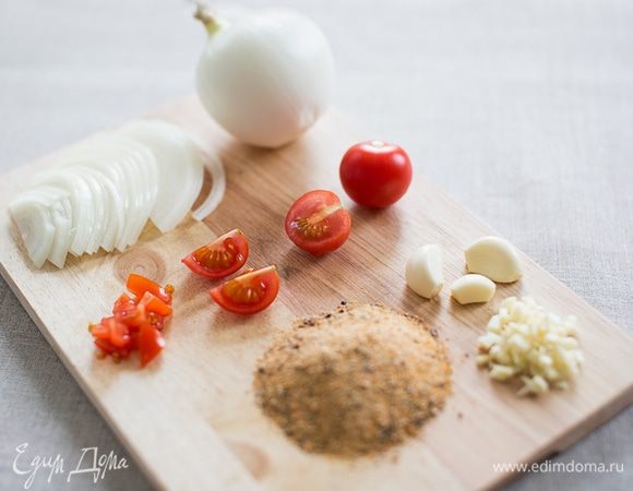 Мелко нарезаем помидоры и отправляем к мясу. Кстати, помидоры можно измельчить с помощью блендера или комбайна. Помидорный сок сделает мясо сочнее. Далее измельчаем чеснок, нарезаем полукольцами лук и добавляем все к мясу. Чесночно-луковый сок добавит курице приятный аромат и вкус, а также сделает мясо еще мягче.