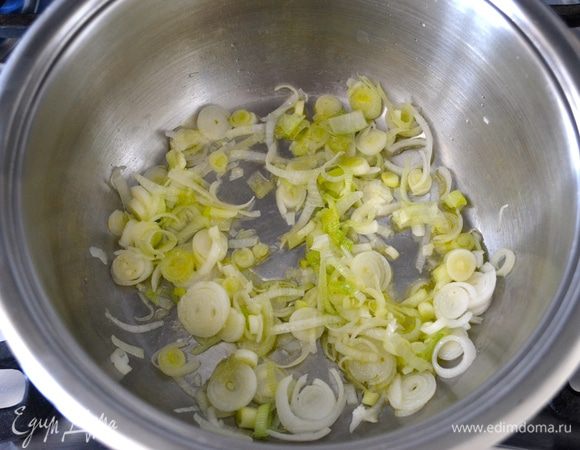 Зеленый лук вымыть и мелко нарезать. Обжарить его слегка в небольшой кастрюле с добавлением небольшого количества оливкового масла (1.5 ст.л.).