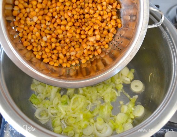 Консервированную чечевицу как следует промойте и слейте, добавьте в кастрюлю к луку. Перемешайте все в течение одной минуты.