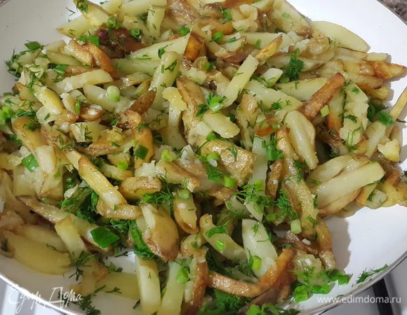Когда картошка хорошо поджарится со всех сторон, добавить мелко нарубленный чеснок, посолить, накрыть крышкой, убавить огонь и прогреть несколько минут. Затем добавить зелень, аккуратно перемешать, прогреть ещё пару минут и сразу же подавать.