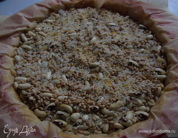 Накрыть пергаментом и насыпать чего не жалко: фасоли, гороха или крупы... а у меня благодаря сынишке есть смесью. Отправить в разогретую до 200 С духовку на 15 минут.