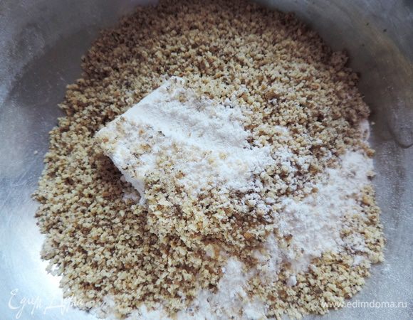 Смешиваем масло из холодильника, сахар, муку и измельченные орехи.